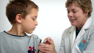 woman inject boy on arm