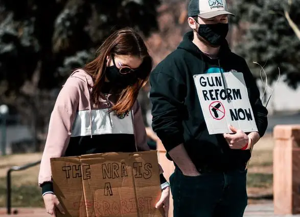 woman in black and white long sleeve shirt holding brown cardboard box